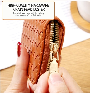 Close-up of brown woven leather card holder featuring a premium gold metal zipper puller