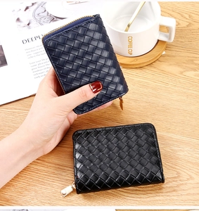 Close-up of woven texture credit card holders in navy and black with gold zippers