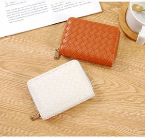 Detail view of woven texture card holders in brown and white on a wooden desk with coffee