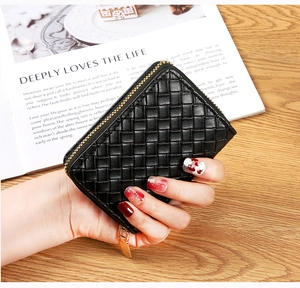 Detail view of woven black leather card holder with premium gold zipper and luxury finish