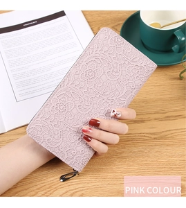 Gros plan sur un long portefeuille rose pour femme avec texture dentelle embossée