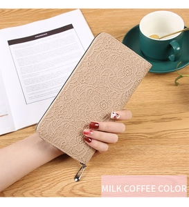 Détail du portefeuille long couleur café au lait avec dentelle sur table en bois