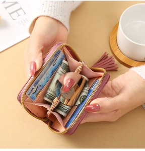 Detail view of pink leather wallet with card slots, coin zipper and tassel puller