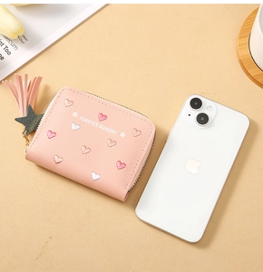 Pink leather wallet size comparison with phone showing heart embroidery and tassel detail