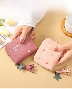 Close-up of women's short leather wallet with heart embroidery and tassel star charm