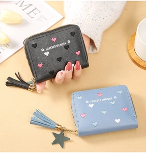 Detailed shot of leather wallet with heart embroidery, tassel and star charm
