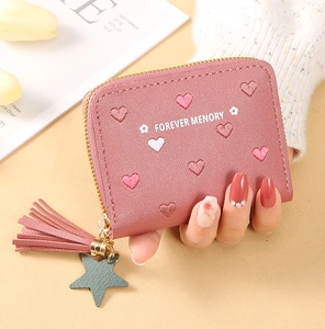Pink leather wallet detail with heart embroidery, tassel zip and star charm