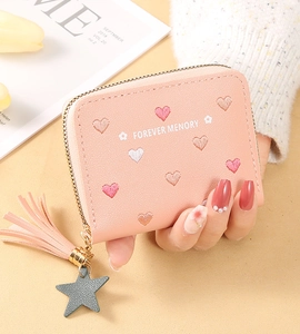 Pink zippered wallet featuring heart embroidery, leather tassel and star charm detail