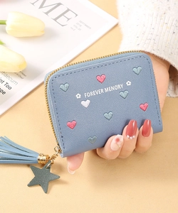 Detail of light blue wallet featuring colorful heart embroidery and star tassel pendant
