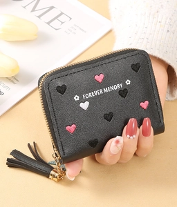 Close-up of litchi leather wallet featuring heart embroidery and leather tassel detail