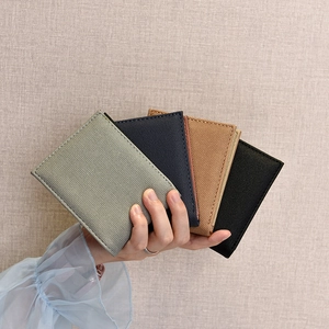 Slim bi-fold wallet for men in four colors showing its lightweight canvas texture
