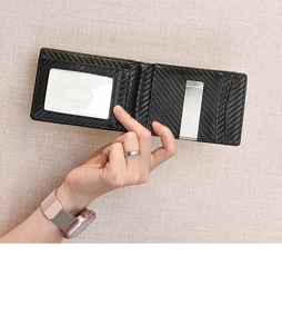 Detailed view of bifold wallet featuring a carbon fiber texture and silver metal money clip