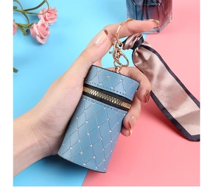Detail of light blue quilted mini pouch with golden ring clasp and brown silk bow