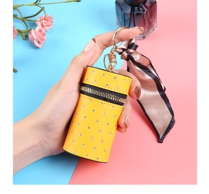 Detail of yellow quilted lipstick pouch with sparkling rhinestones and a silk ribbon scarf