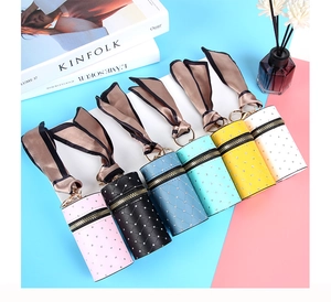 Close-up of mini bucket bag charms in six colors with quilted texture and silk scarves