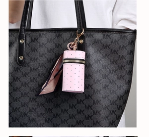 Close-up of a pink mini bucket bag charm with rhinestones and silk scarf detail