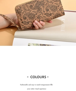 Portafoglio lungo in sughero con stampa paisley e cerniera dorata tenuto in mano
