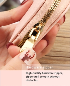 Close-up of a smooth gold metal zipper on a pink litchi grain PU leather card holder