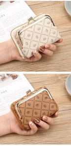 Detail of short leather wallet with heart print, metal clasp and side zipper compartment