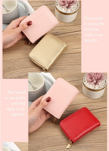 Close-up of pebble-textured leather coin purses in pink and gold with metal zippers