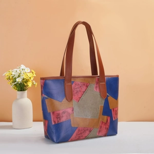 Gros plan du sac cabas rétro en patchwork aux motifs géométriques colorés sur surface blanche