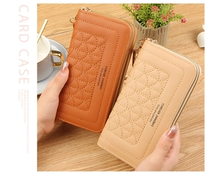 Detail view of quilted long zip-around wallets for women on a rustic wooden desk