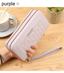 Detail of purple long double-zipper wallet with embroidered texture and wrist strap