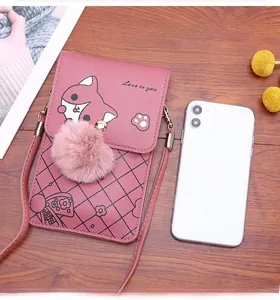 Pink leather crossbody bag size comparison with iPhone 11 showing fox print and pom-pom