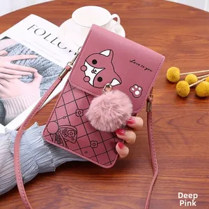 Detail of dark pink textured leather phone bag with fox print and soft pompom charm