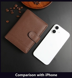 Braune Leder-Reisepasshülle im Größenvergleich mit einem iPhone auf dunklem Hintergrund