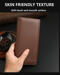 Detailed texture of brown Saffiano leather wallet with embossed logo on a black background