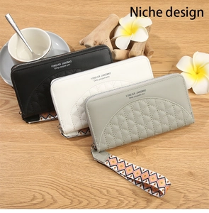 Three long zip-around wallets with quilted semicircular patterns and woven wrist straps