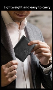 Close-up of a slim black leather wallet being placed into a suit jacket pocket