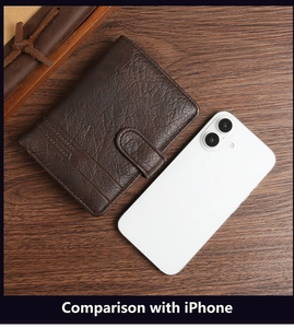 Retro brown PU leather wallet size comparison with iPhone on dark wooden desk surface