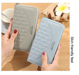 Detail of long quilted zip wallets in gray and light blue with wave stitching