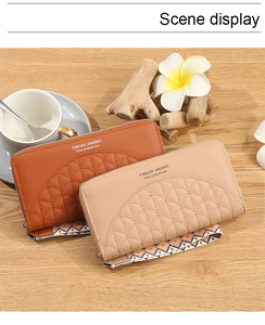 Detail of long quilted leather wallets with ethnic wrist straps on a rustic wood surface