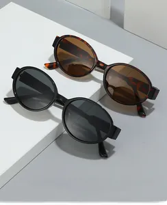 Close-up of black and tortoiseshell oval sunglasses on minimalist geometric props