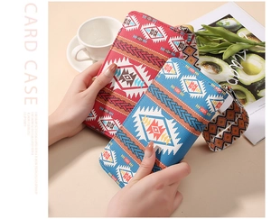 Detailed view of ethnic print zip wallets with wide wrist straps in red and blue canvas