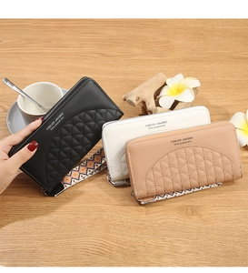 Three elegant long zip wallets in black, white, and pink on a rustic wooden table
