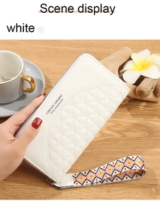 Close-up of cream long wallet featuring quilted pattern and colorful woven wristlet strap