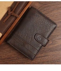 Detail of dark brown leather wallet with snap closure and retro lychee texture design