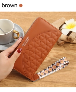 Close-up of brown PU leather long wallet with fish scale quilting and woven wristlet