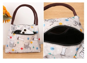 Detail of cartoon lunch bag showing the front zipper pocket with phone and top handles