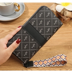 Detailed view of long black faux leather wallet with bohemian style woven wrist strap