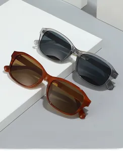Gros plan de lunettes de soleil carrées gris transparent et écaille avec branches en métal