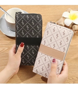 Detail showing long zip-around wallets with monogram pattern in black and beige colors