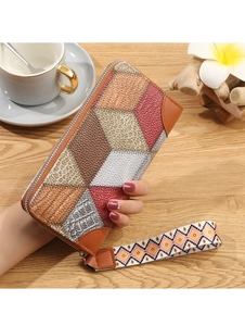 Dettaglio di un portafoglio lungo con design patchwork geometrico e cinturino stampato