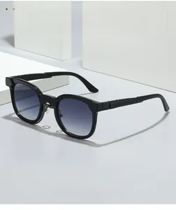 Close-up of gloss black frame and blue gradient lenses on a minimalist sunglasses detail