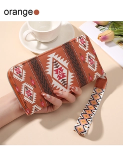 Detail of orange bohemian long wallet featuring ethnic geometric patterns and wrist strap