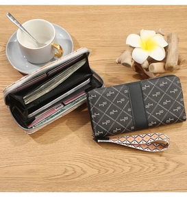 Detailed interior of a monogram zip wallet with card slots and a patterned wristlet strap